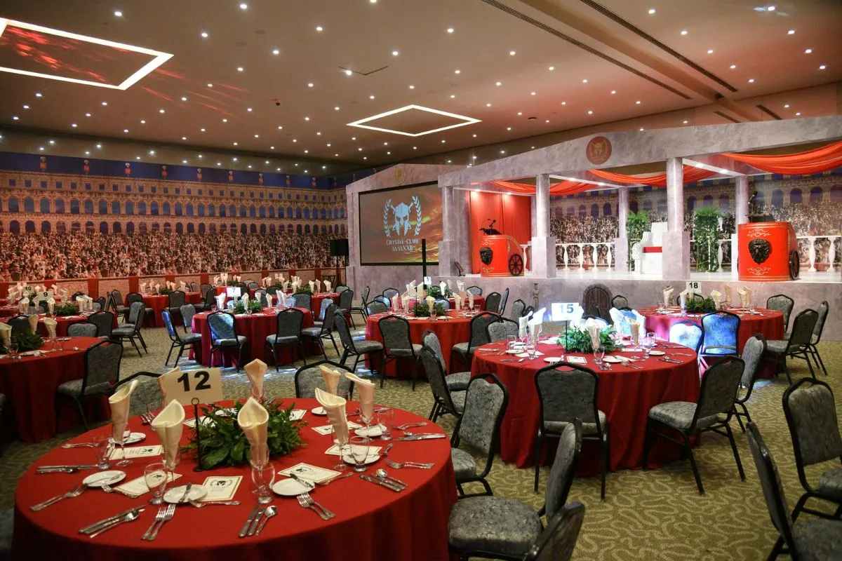 Elegant themed banquet hall setup with round tables and stage design reflecting detailed event planning for corporate events