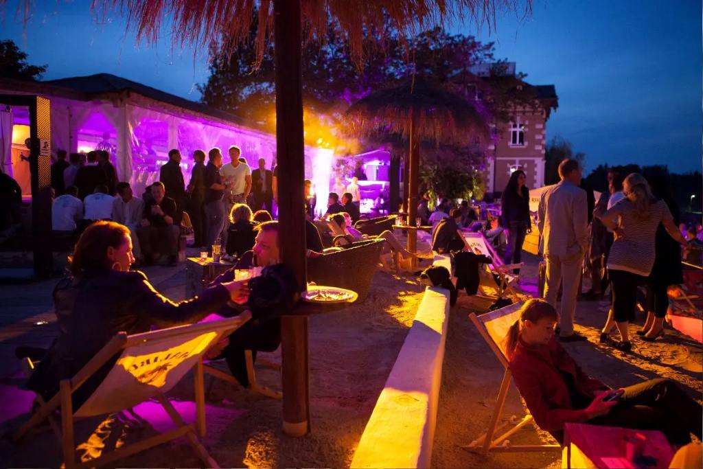 Outdoor evening corporate event with ambient lighting and lounge seating showcasing creative event planning for corporate events